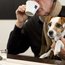 Mann trinkt Kaffee und hält Jack-Russell-Terrier im Arm